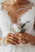 sposa è Tenere boutonniere nel sua mani. nozze fiori. foto