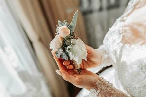 sposa è Tenere boutonniere nel sua mani. nozze fiori. foto