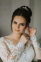 il sposa indossa bellissimo nozze orecchini. ragazza con pettinatura e professionale trucco indossa gioielleria Accessori foto