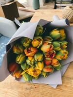 mazzo di tulipani nel un' scatola su un' di legno tavolo foto