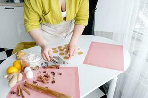 ritagliata tiro di donna fabbricazione Pan di zenzero biscotti a tavolo nel cucina foto