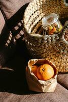 mandarini e noccioline nel un' di vimini cestino su il divano foto