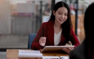 riunione di squadra.gruppo di due uomini d'affari che lavorano con un nuovo progetto di avvio in un ufficio moderno.touch pad nelle mani di una donna foto