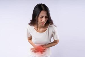 ritratto di donna asiatica che soffre di mal di stomaco isolato su sfondo bianco foto
