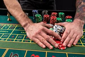 un' avvicinamento vivace Immagine di verde casinò tavolo con roulette, con il mani di croupier e multicolore patatine fritte. foto