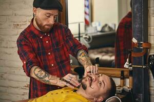 cliente durante barba rasatura nel barbiere negozio foto