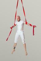 atletico uomo nel un' bianca sport completo da uomo è l'esecuzione un acrobatico elementi nel un' studio. foto