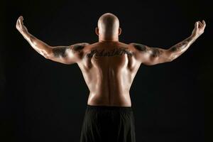 atletico Calvo, barbuto, tatuato uomo nel nero pantaloncini è in posa contro un' nero sfondo. avvicinamento ritratto. foto