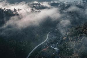 il sole sorge nella nebbia e nelle montagne al mattino foto