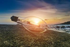 spazzatura lampadina sulla spiaggia con la luce del sole. foto