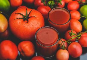 mescolare pomodori e succhi in un bicchiere. foto
