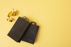 borse per la spesa nere in vendita venerdì nero piatte su sfondo giallo con ghirlanda festiva