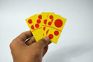 mano hold domino giocando carte isolato bianca sfondo, giallo rosso domino carte foto