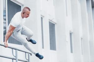 giovane sportivo che fa parkour in città foto