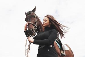 una ragazza felice comunica con il suo cavallo preferito. la ragazza ama gli animali e l'equitazione foto