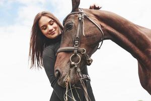 una ragazza felice comunica con il suo cavallo preferito. la ragazza ama gli animali e l'equitazione foto