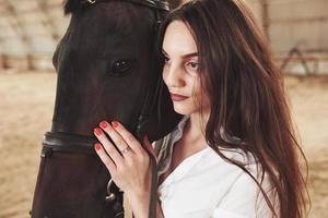una ragazza felice comunica con il suo cavallo preferito. la ragazza ama gli animali e l'equitazione foto