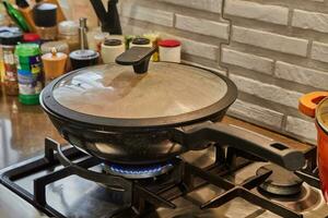 frittura padella con bicchiere coperchio su il fuoco di gas stufa foto