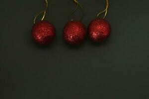 tre rosso Natale palline su nero sfondo con copia spazio per il tuo testo foto