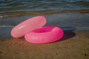 figli di nuoto anelli. rosa gonfiabile cerchi per spiaggia. foto