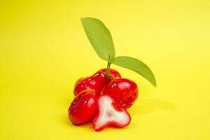 fresco acqua Mela frutta e alcuni acqua Mela su cestino dietro a su giallo sfondo foto