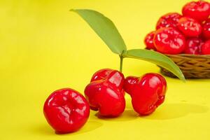 fresco acqua Mela frutta e alcuni acqua Mela su cestino dietro a su giallo sfondo foto