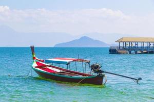 barca a coda lunga al molo sull'isola di koh phayam thailandia. foto