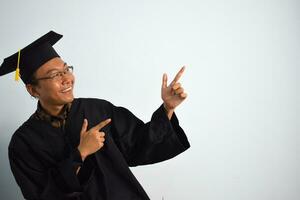 espressive di adulto Indonesia maschio indossare la laurea veste, cappello e occhiali isolato su bianca sfondo, espressioni di ritratto la laurea foto