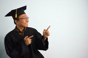 espressive di adulto Indonesia maschio indossare la laurea veste, cappello e occhiali isolato su bianca sfondo, espressioni di ritratto la laurea foto