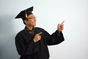 espressive di adulto Indonesia maschio indossare la laurea veste, cappello e occhiali isolato su bianca sfondo, espressioni di ritratto la laurea foto