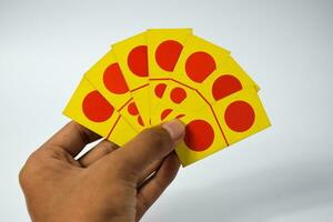 mano hold domino giocando carte isolato bianca sfondo, giallo rosso domino carte foto