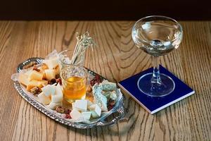 diversi tipi di formaggio sul vassoio e cocktail foto