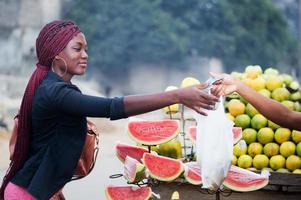 giovane donna che compra frutta. foto