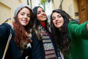 gruppo di tre donne felici che camminano insieme all'aperto foto