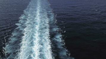 aereo superiore Visualizza di un' bellissimo rotaia su il mare o oceano superficie dietro a di velocità crociera rivestimento. scorta. scia nel il oceano fatto di grande nave. foto