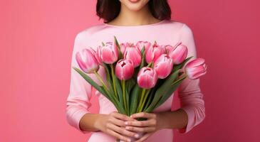 ai generato un' donna vestito nel rosa Tenere un' snello mazzo di tulipani foto