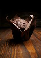 cioccolato Cupcake su un' buio sfondo. focaccina con cioccolato patatine fritte su un' di legno superficie. foto