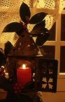 un' candela è illuminato nel un' piccolo lanterna con un' rosso candela foto