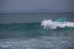 tavola da surf inversa nell'oceano foto