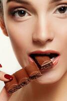 bello sorridente adolescenziale ragazza mangiare cioccolato foto