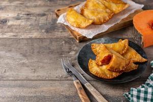 empanadillas di zucca sulla tavola di legno. cibo autunnale foto