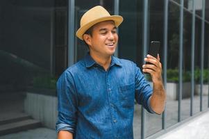 giovane uomo asiatico che utilizza smartphone.