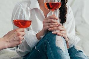 una giovane donna tiene un bicchiere di vino rosato foto