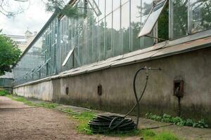 gomma da cancellare irrigazione tubo flessibile vicino il parete di il serra, serra complesso infrastruttura foto