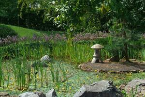 pietra lanterna su un' piccolo isola nel il mezzo di un' stagno nel un' giapponese giardino foto