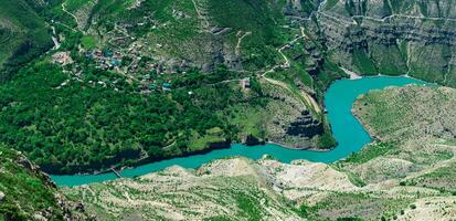 superiore Visualizza di il montagna fiume sulak nel daghestan con il villaggio di vecchio zubutli con un' barca molo foto