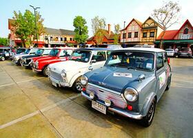 ayutthaya, Tailandia - dicembre 6, 2023 molti colorato classico mini bottaio parcheggio e mostrando nel vecchio auto Festival con Casa e cielo per sfondo. mezzi di trasporto e Vintage ▾ veicolo concetto foto