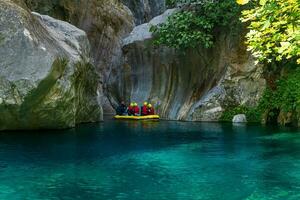 turisti e guida su un gonfiabile barca galleggiante giù un' roccioso canyon con blu acqua nel goynuk, tacchino foto