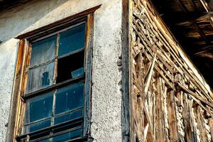 vecchio abbandonato di legno Casa con rotto bicchiere, frammento foto