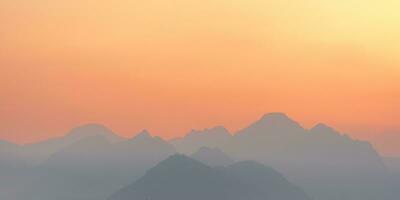 luminosa tramonto o Alba cielo con nebbioso montagne foto